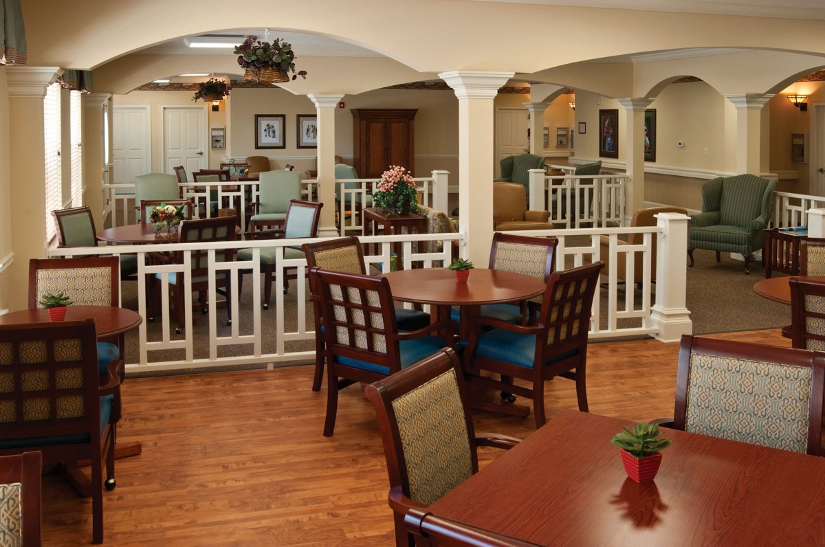A cozy dining area with wooden tables and chairs, featuring elegant decor and a warm ambiance.