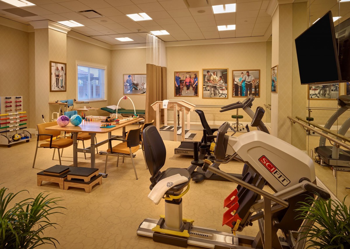 A well-equipped physical therapy and rehabilitation room with exercise machines and equipment.