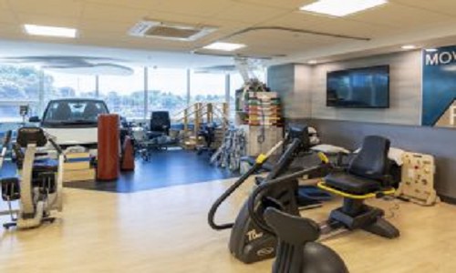 A spacious gym with various exercise equipment and cardio machines.
