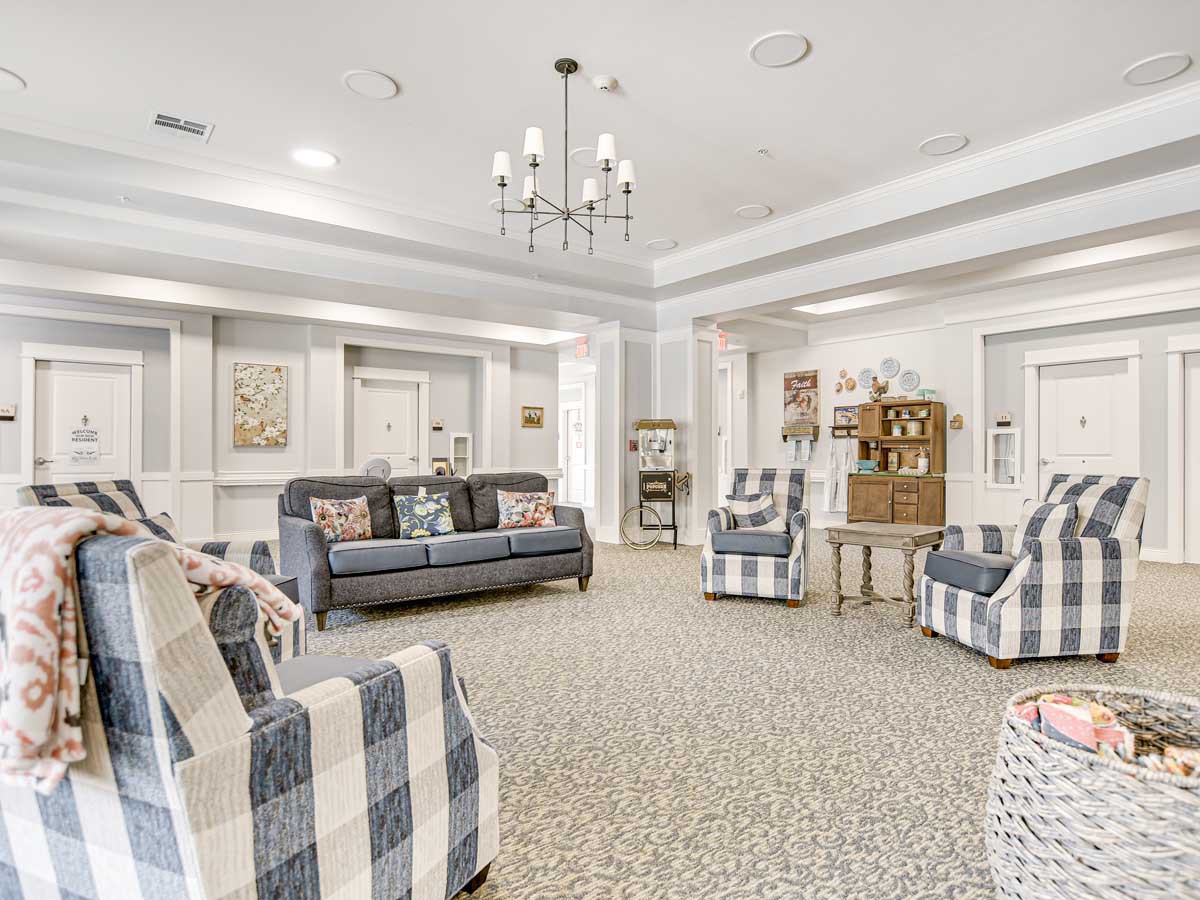 A cozy living room with patterned armchairs, a dark sofa, and elegant decor.