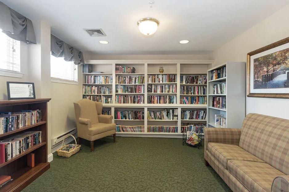 A cozy library space with bookshelves filled with books and comfortable armchairs.