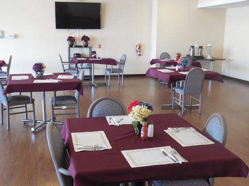 A welcoming dining area set up with tables adorned in purple tablecloths, creating a cozy atmosphere for guests.
