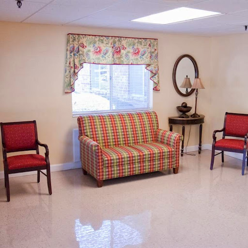 A cozy living room setup featuring a patterned sofa and red chairs.