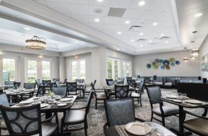 A modern and elegant dining room with neatly arranged tables and chairs, featuring soft lighting and a spacious layout.