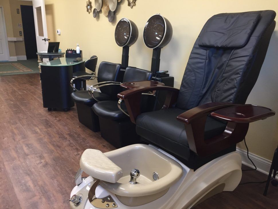An interior view of a beauty salon with pedicure chairs and hair dryers.