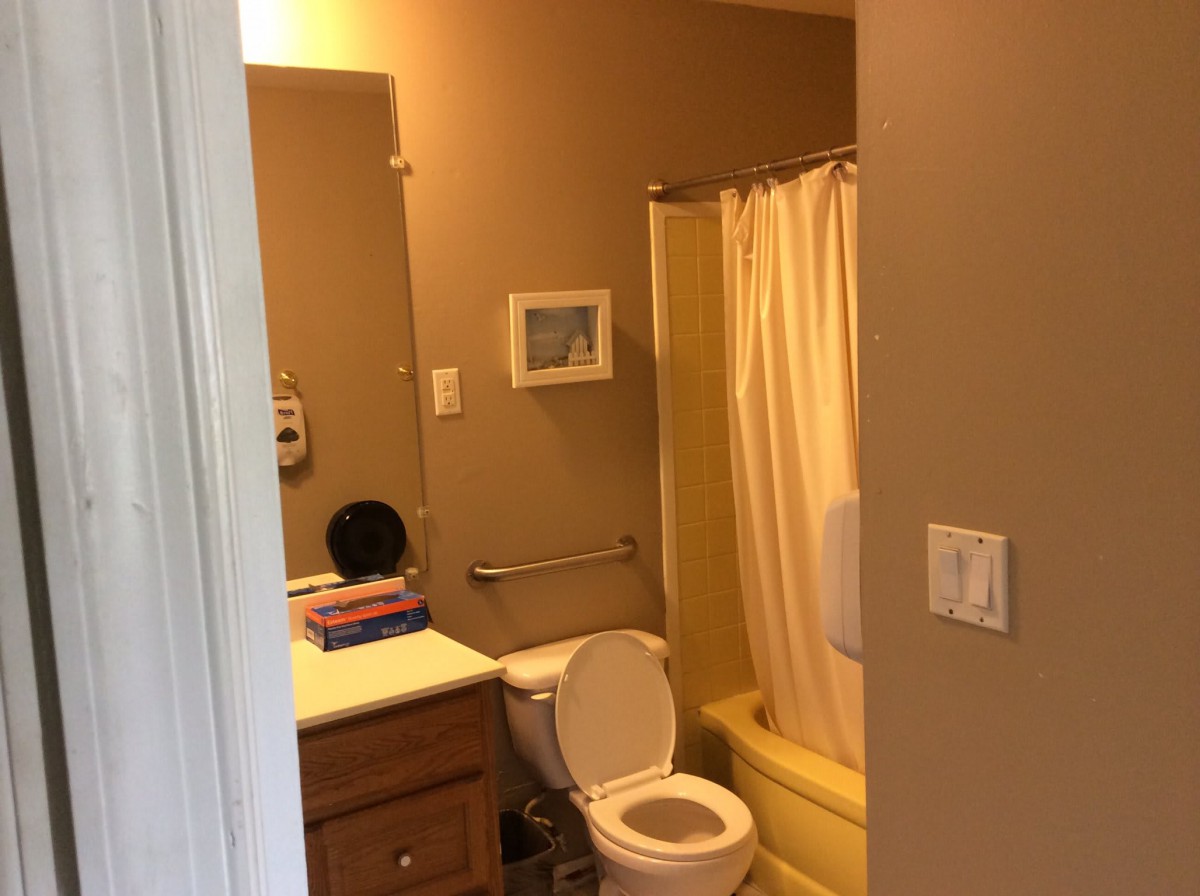 A small bathroom with a toilet, sink, and shower curtain.