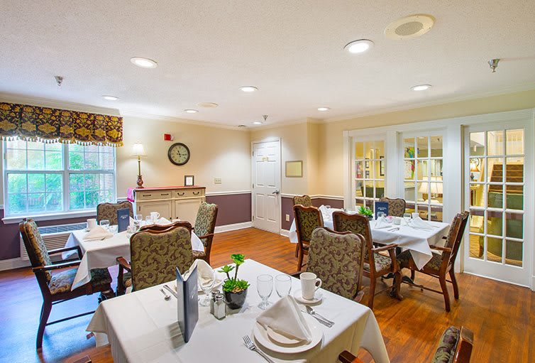 A cozy dining room with elegantly set tables and chairs.