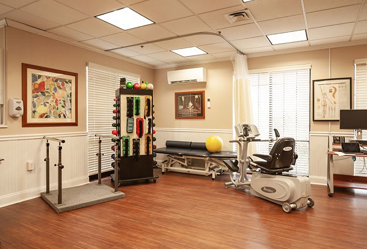 A well-equipped rehabilitation room featuring various exercise equipment for physical therapy.