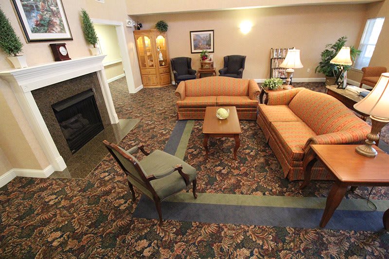 A cozy living room with sofas, a fireplace, and decorative elements.