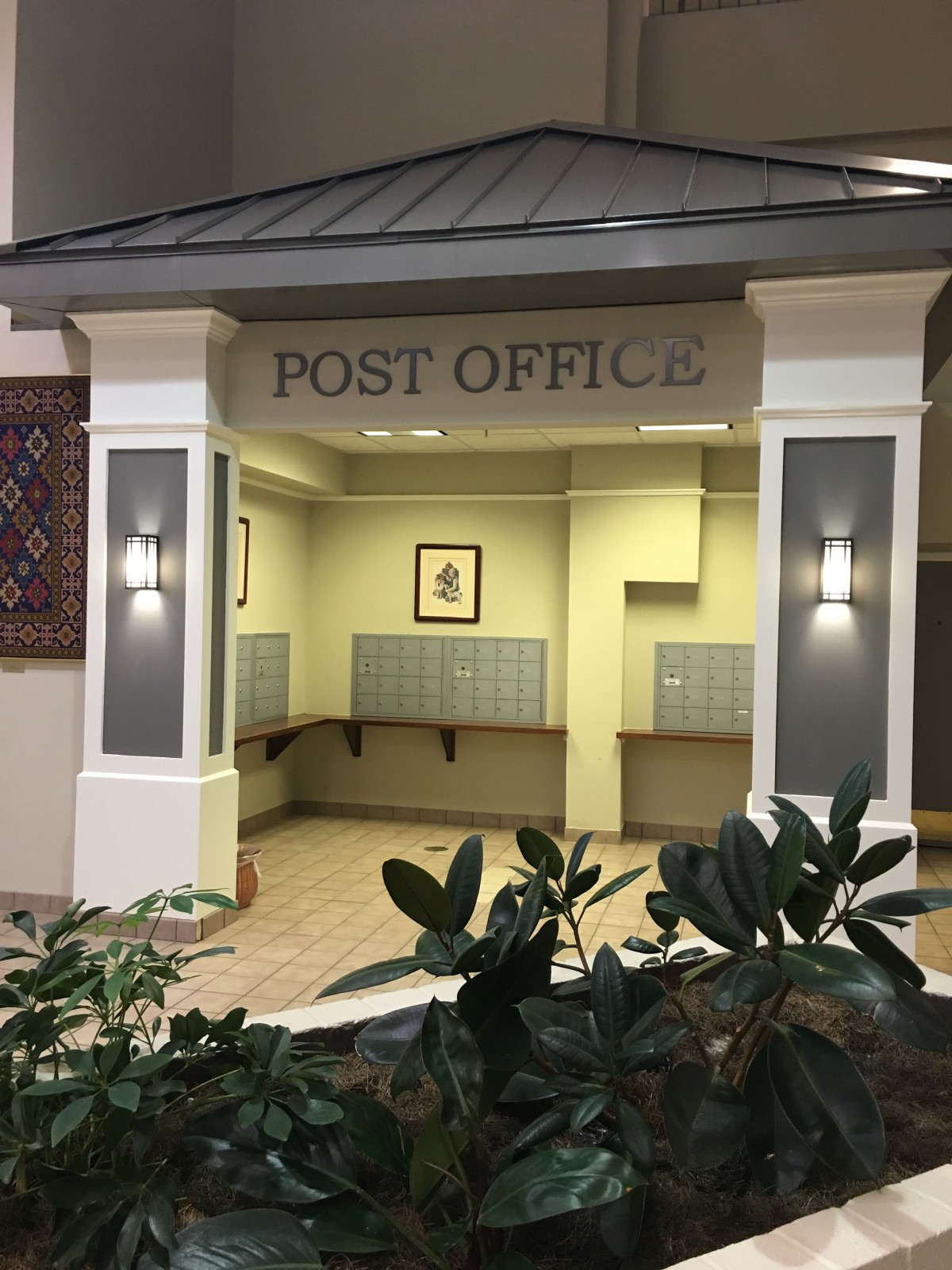 A quaint indoor post office with mail lockers and decorative elements.