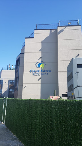 A modern building featuring a colorful logo against a clear blue sky.