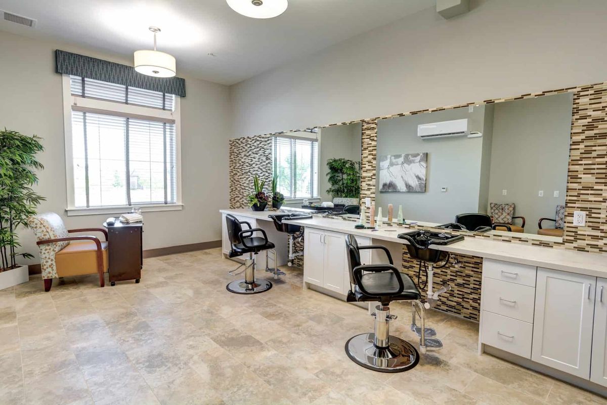 A modern hair salon interior with styling chairs and large mirrors.