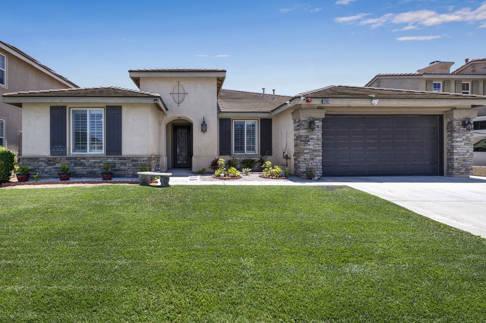A modern single-story house with a well-maintained lawn and a two-car garage.