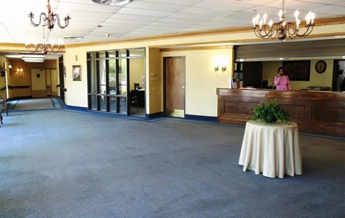 A spacious lobby with a reception desk and carpeted flooring.