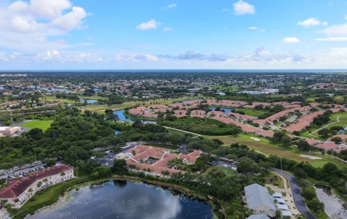 An aerial view of a suburban residential area with lakes and greenery.