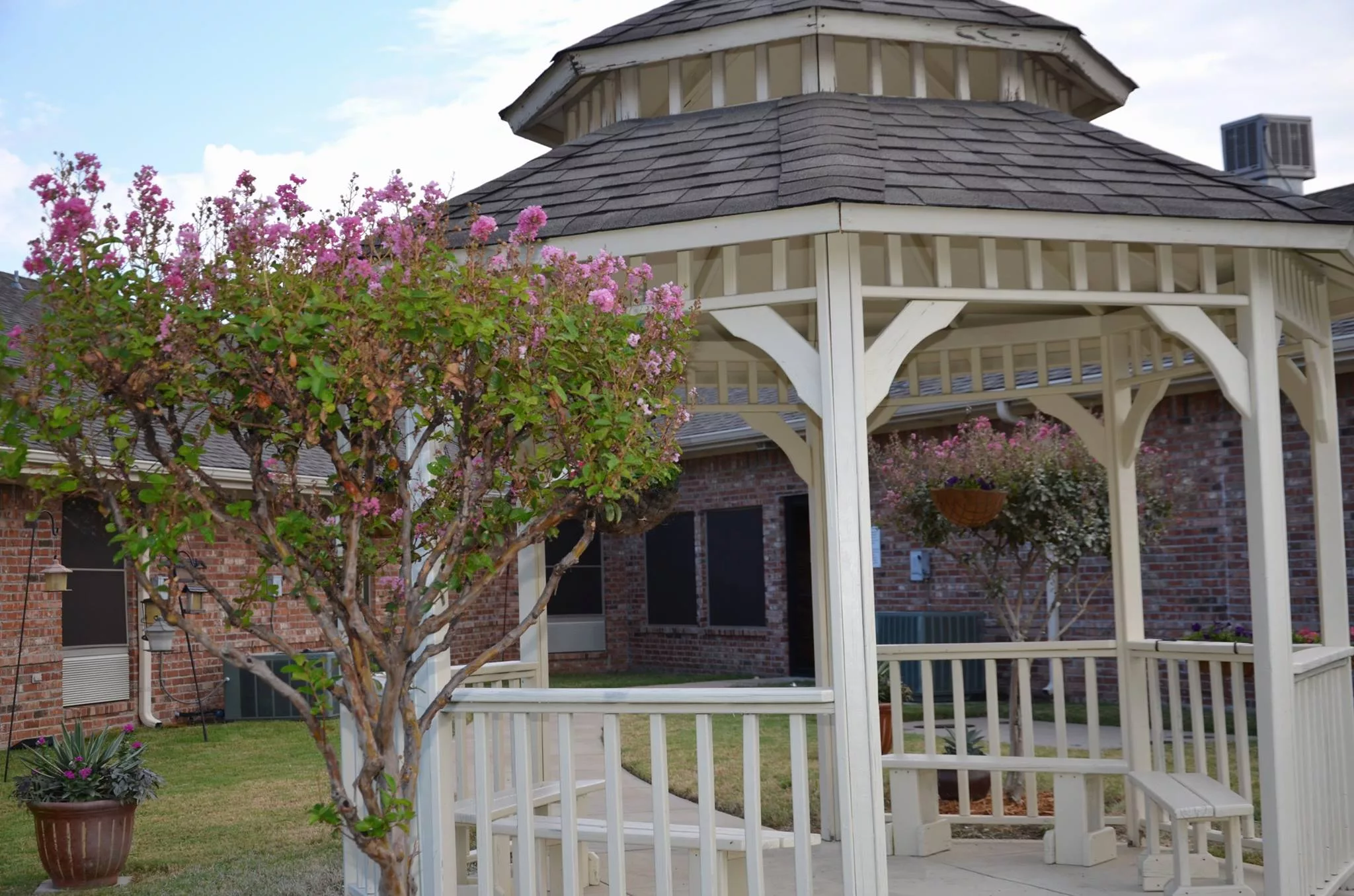 A charming gazebo surrounded by blooming flowers in a garden setting.