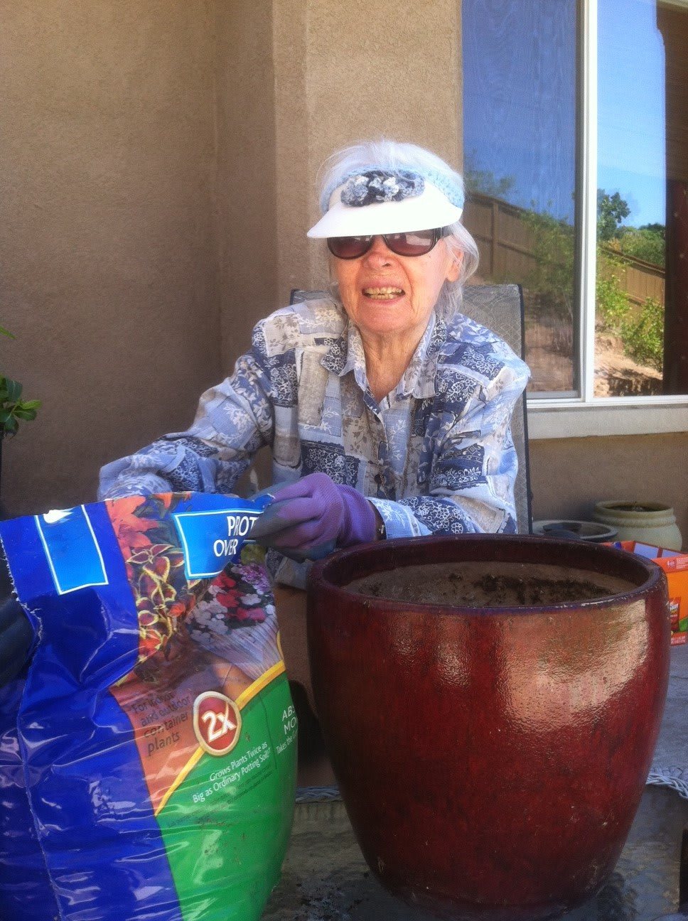 An elderly person enjoying a sunny day while preparing soil for gardening.