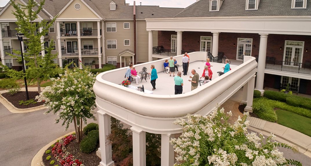 A group of elderly individuals enjoying a fitness session on a rooftop patio.