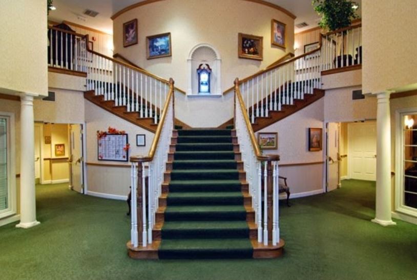 Symmetrical staircase with carpeted steps and artwork on the walls.