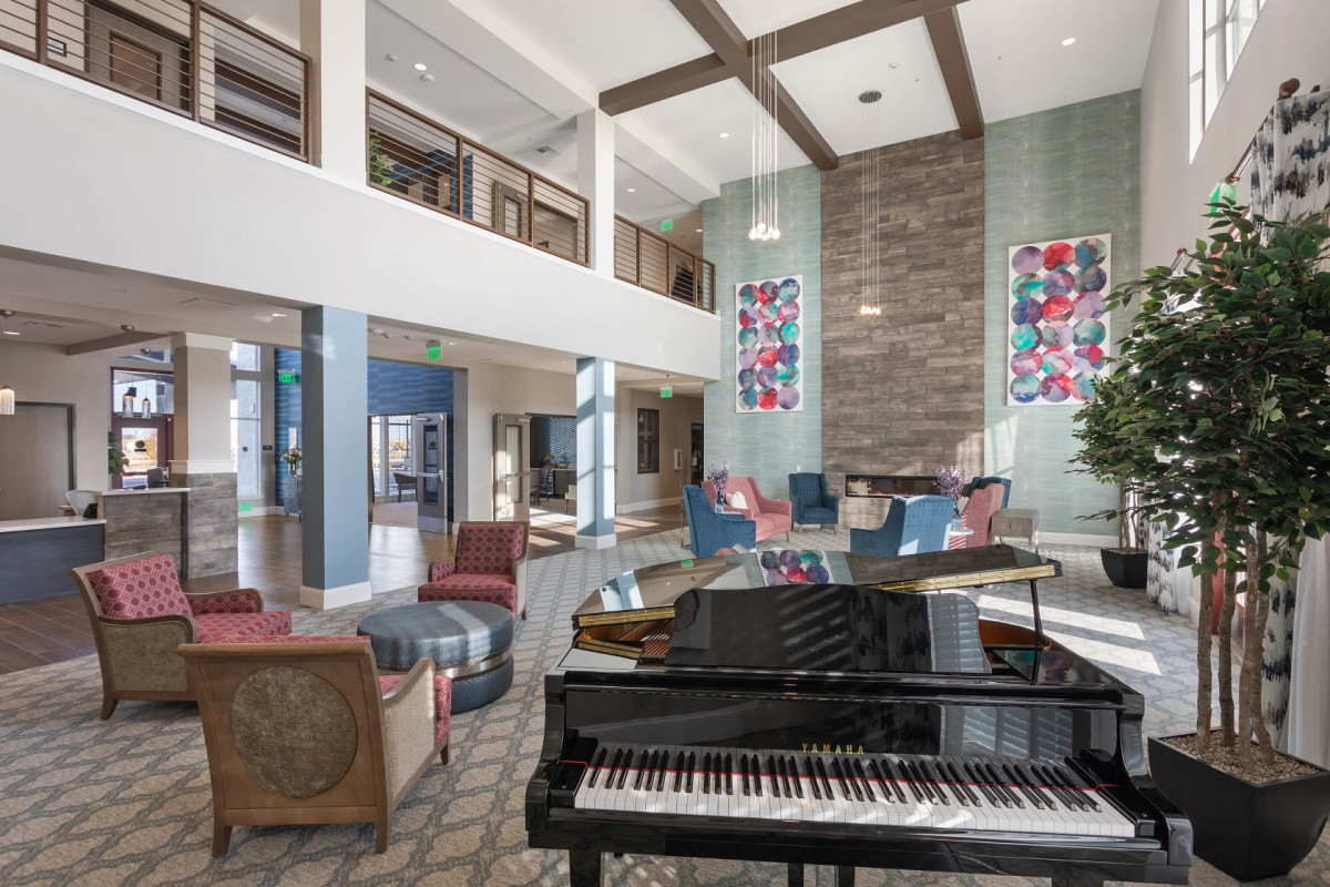 A modern and spacious lobby featuring a grand piano and comfortable seating areas.