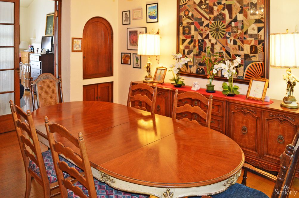 A cozy dining room with a wooden table and chairs, adorned with wall art and decorative pieces.