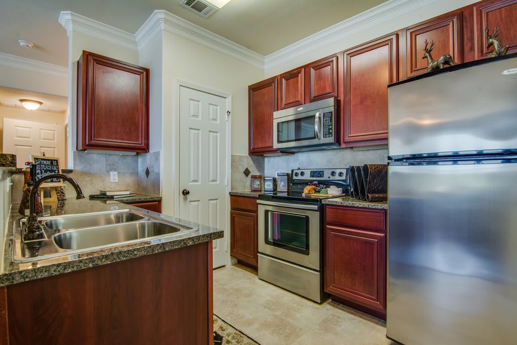 A modern kitchen with stainless steel appliances and wooden cabinets.