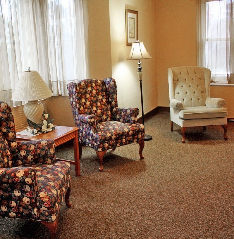 A cozy seating area with floral upholstered chairs and soft lighting.