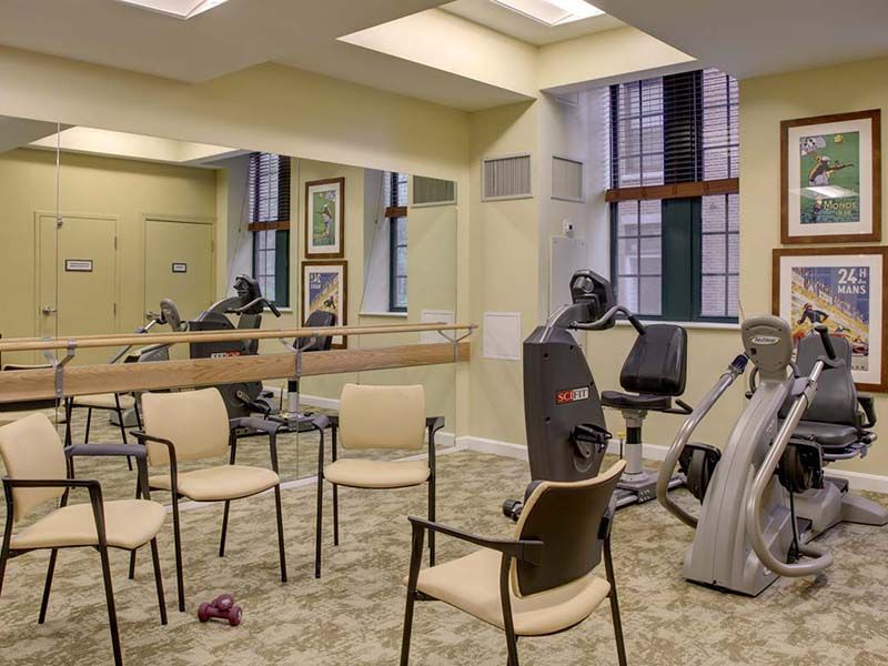 A small fitness center featuring exercise bikes and chairs for workouts.