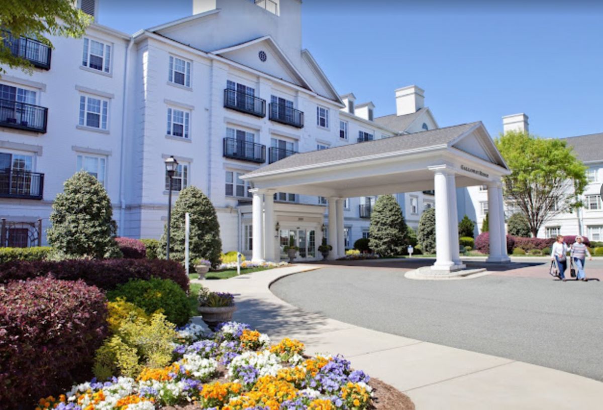 Elegant hotel entrance surrounded by vibrant flowers.