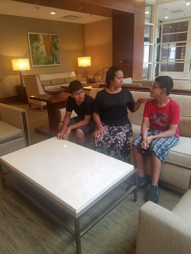 A mother engages in conversation with her two children in a cozy lounge setting.