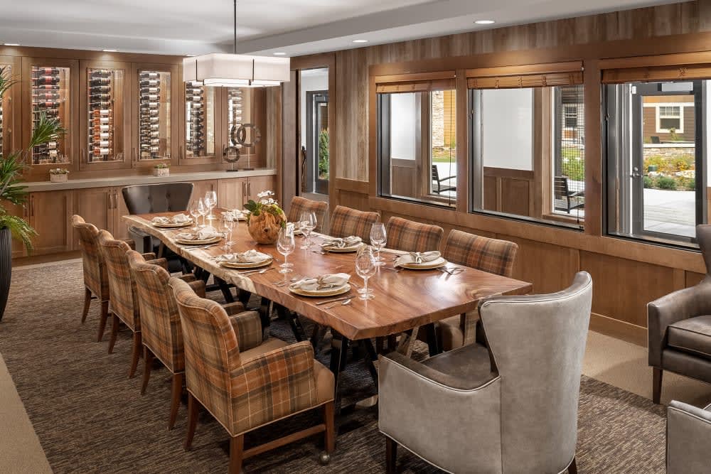A cozy dining room featuring a large wooden table, comfortable chairs, and modern lighting.