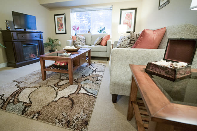 A cozy living room with a comfortable sofa, wooden coffee table, and decorative rug.
