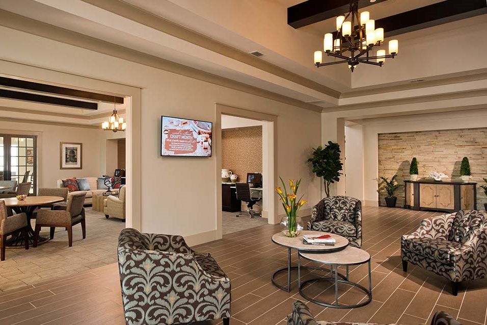 A cozy lobby with elegant furnishings, a central chandelier, and decorative plants.