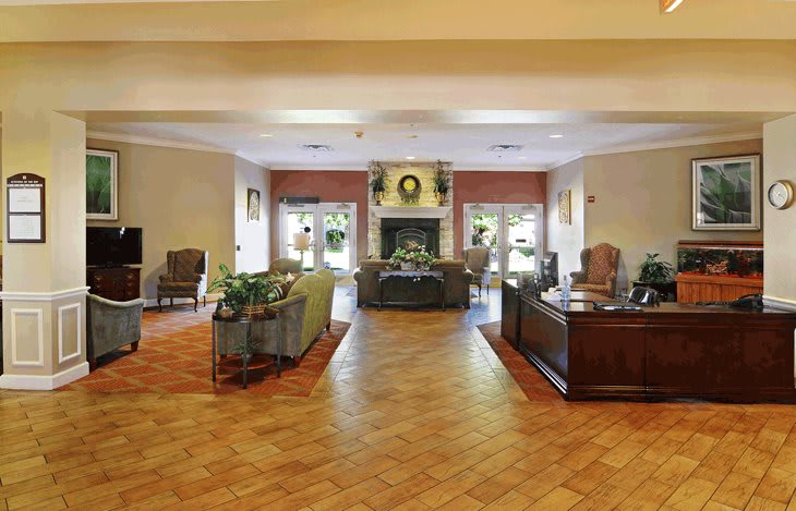 A spacious lobby with elegant furniture and a central fireplace.