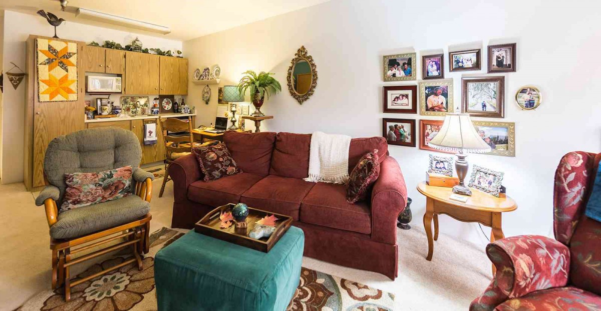 A cozy living room featuring a red sofa, decorative wall art, and warm lighting.