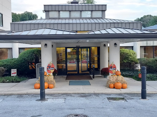 A welcoming entrance decorated with pumpkins and hay bales for the fall season.