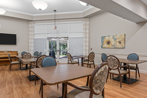 A cozy and well-lit dining area featuring tables and chairs, perfect for gatherings.