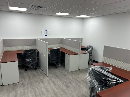 A newly furnished office space featuring multiple empty cubicles and desks.