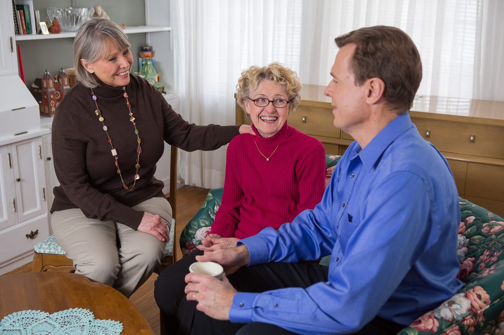 A group of people sitting indoors, engaged in a friendly conversation.