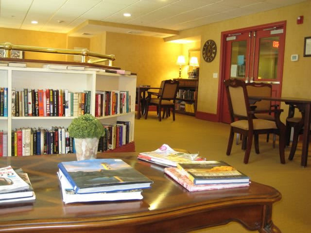 A cozy reading area with books and furniture in a library setting.