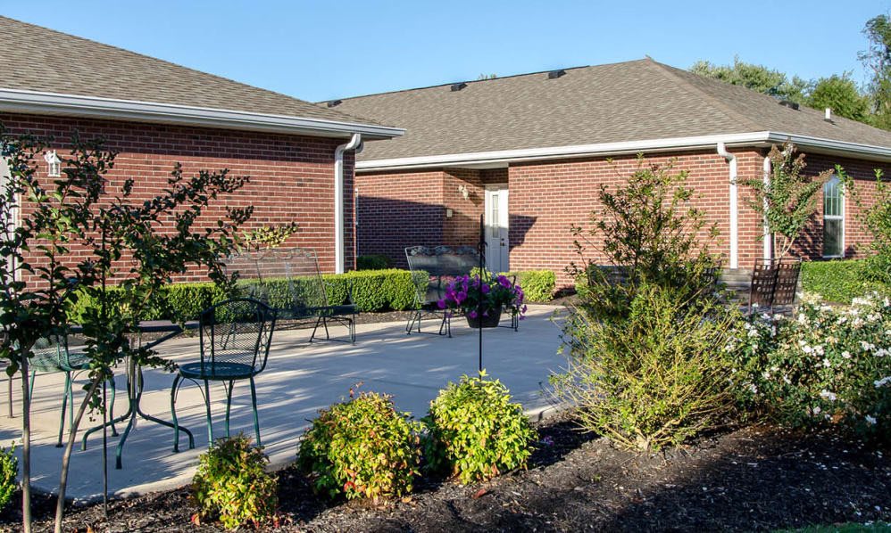 A sunny patio area with outdoor furniture and surrounding greenery.