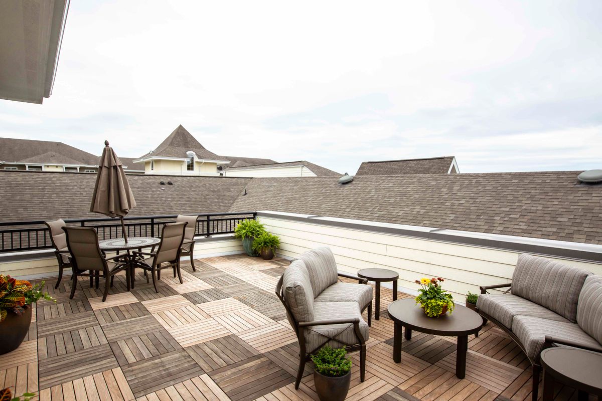 A stylish rooftop patio with comfortable seating and potted plants.