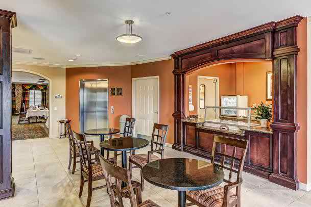 A cozy dining area with multiple tables and chairs, featuring a counter for serving.