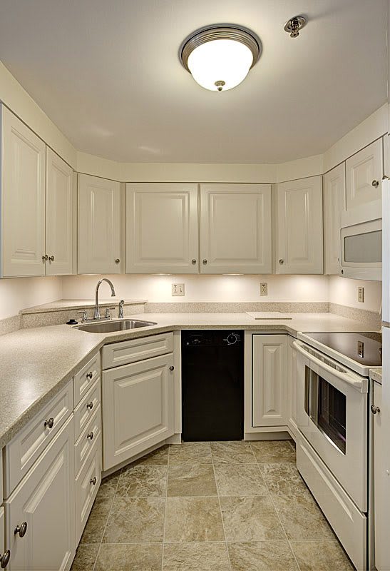 A modern kitchen with white cabinets and sleek appliances.