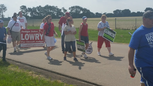 A group of protesters marching with signs on a sunny day.