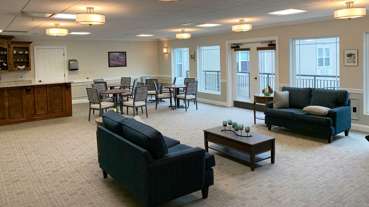 A spacious and well-lit living area with sofas, dining tables, and elegant interior decor.