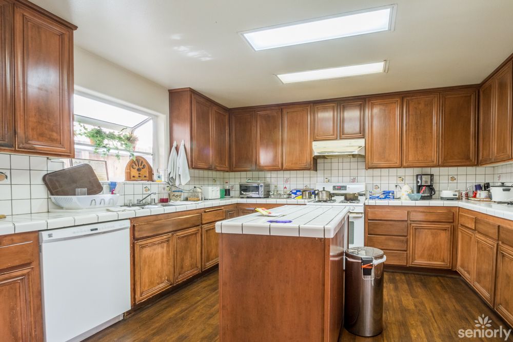 A spacious kitchen with wooden cabinets, a central island, and modern appliances.