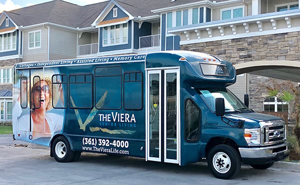 A blue bus with 'The Viera' branding parked in a residential area.