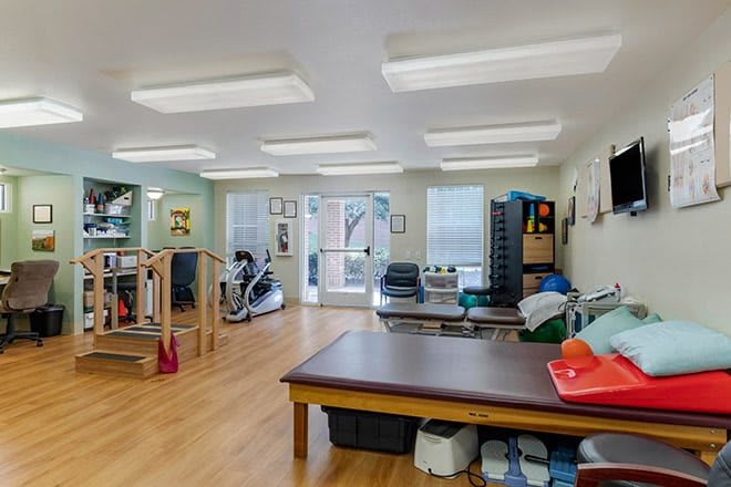 A physical therapy room equipped with various rehabilitation tools and exercise machines.