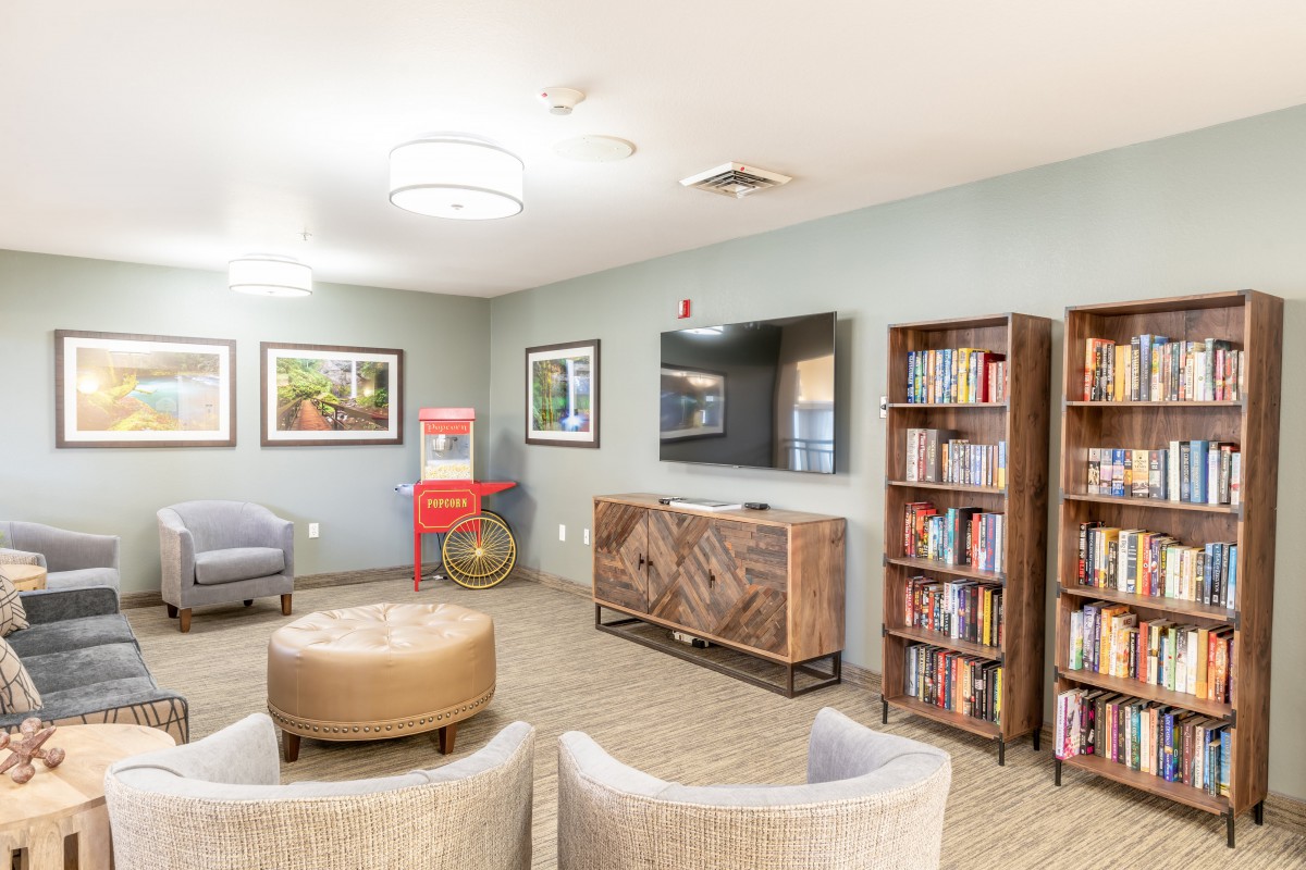 A cozy living room with bookshelves, a TV, and comfortable seating.
